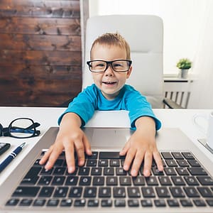 Dítě s brýlemi u počítače - optika Fénix Kroměříž